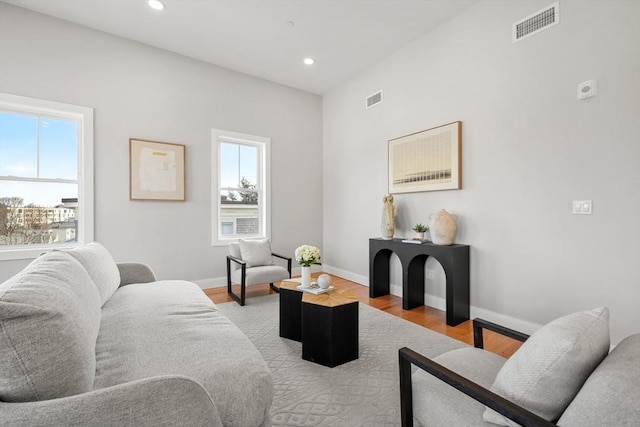 living area with light wood-type flooring, visible vents, and plenty of natural light