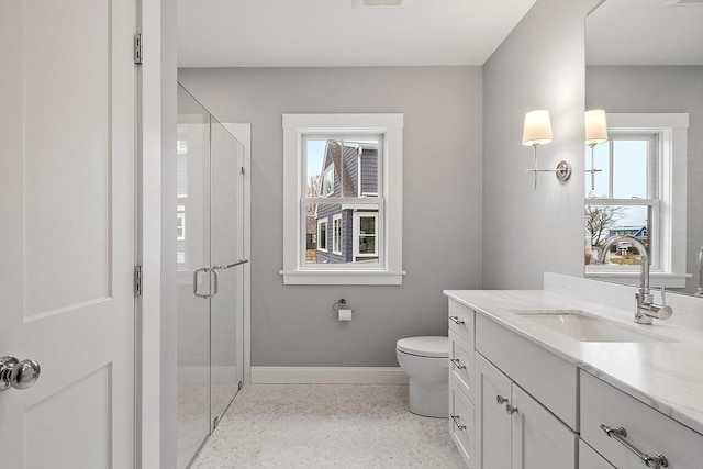 full bathroom with vanity, speckled floor, baseboards, a shower stall, and toilet