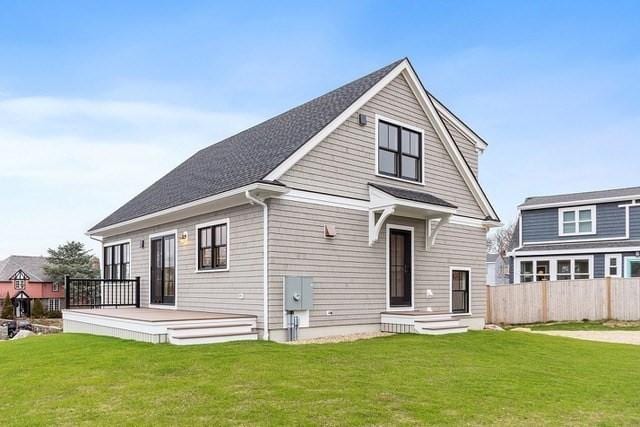 back of property featuring a lawn, fence, and a wooden deck