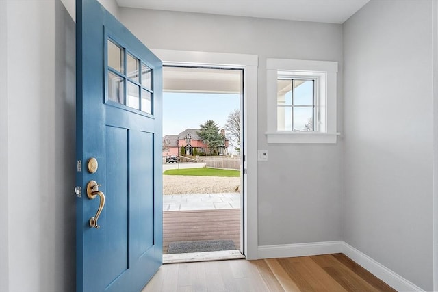 foyer entrance featuring baseboards and wood finished floors