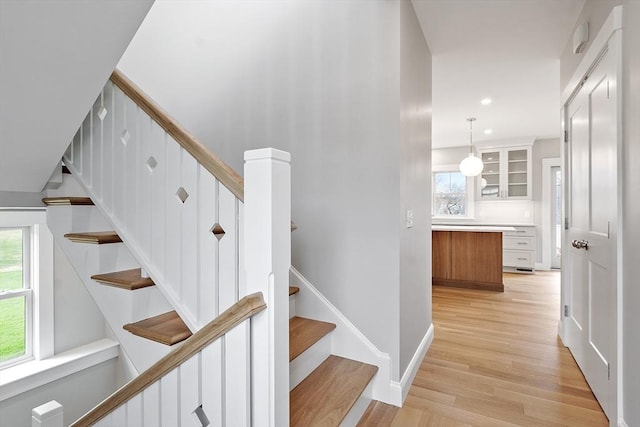 staircase with recessed lighting, baseboards, and wood finished floors