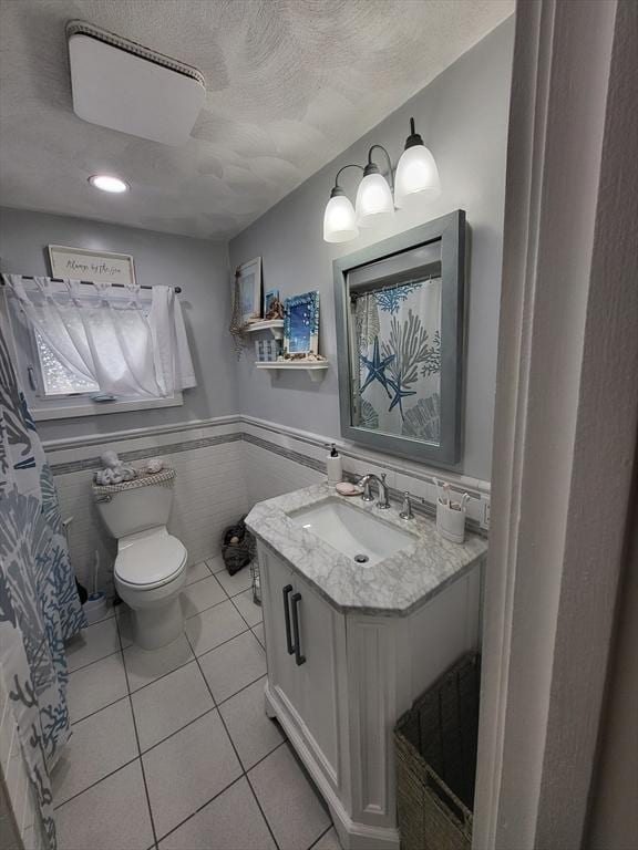 39 Cheever Rd, Malden, MA 02148 - bathroom featuring vanity, a wainscoted wall, tile patterned flooring, a textured ceiling, and tile walls