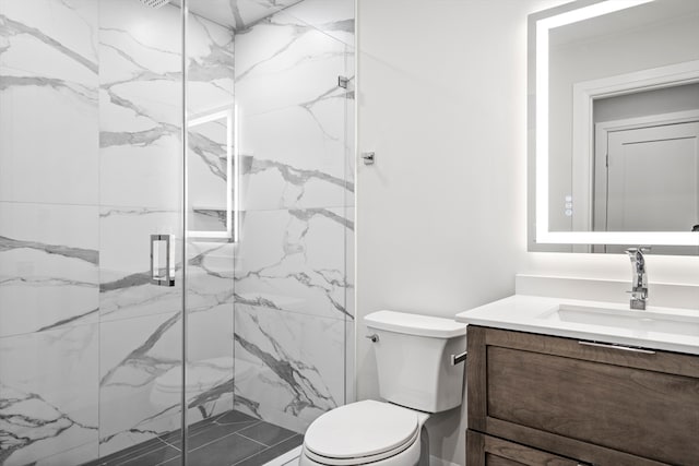 bathroom featuring an enclosed shower, vanity, and toilet