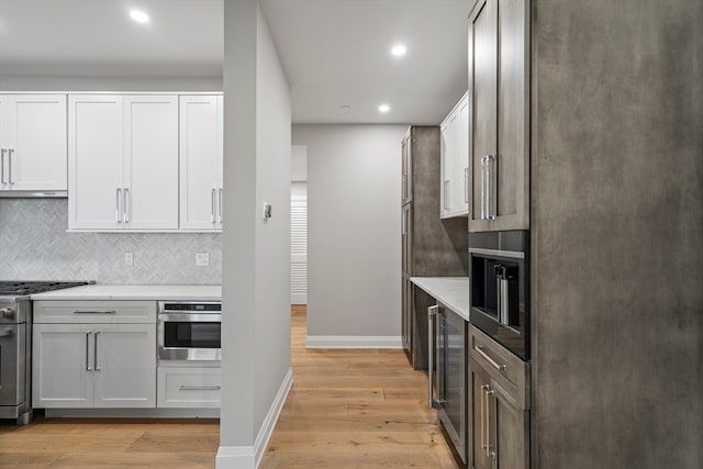 kitchen with wine cooler, light hardwood / wood-style floors, appliances with stainless steel finishes, and white cabinetry