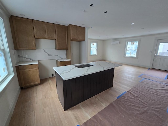 9 Swan St Unit 1, Beverly, MA 01915 - kitchen featuring light wood-type flooring, healthy amount of natural light, light stone counters, and decorative backsplash