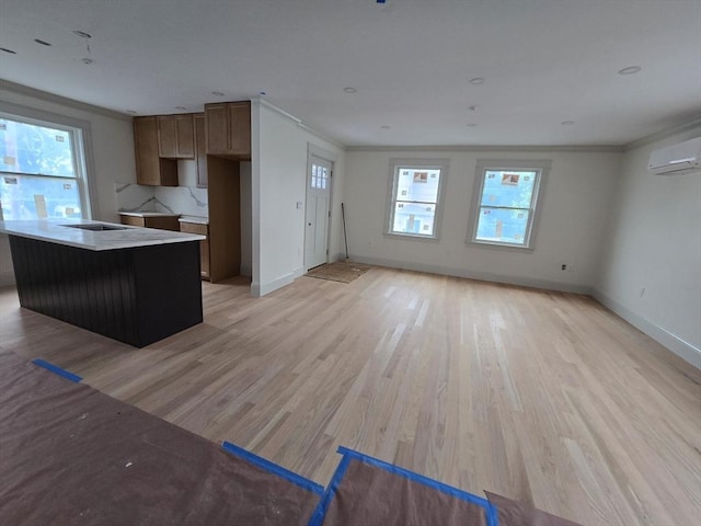 9 Swan St Unit 1, Beverly, MA 01915 - kitchen with light wood-style flooring, ornamental molding, a wall mounted air conditioner, a center island, and open floor plan