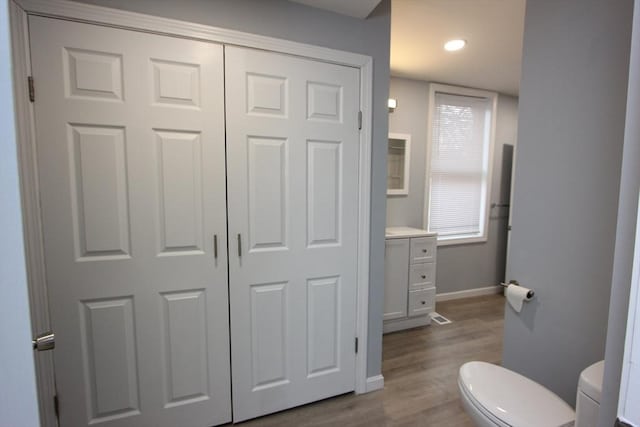 bathroom with hardwood / wood-style floors, vanity, and toilet