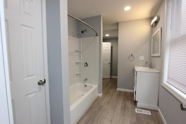 bathroom with hardwood / wood-style flooring, vanity, and shower / tub combination