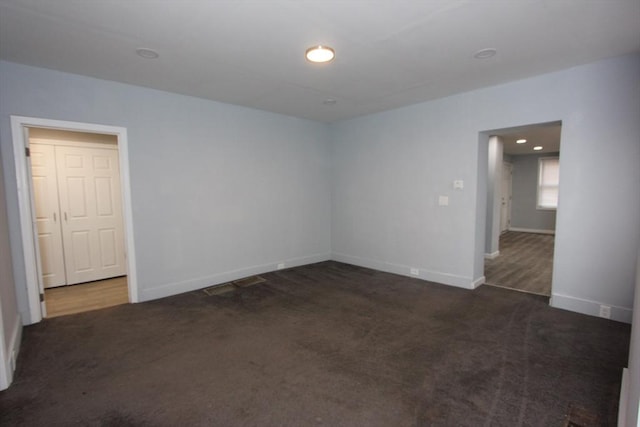 unfurnished room with dark carpet