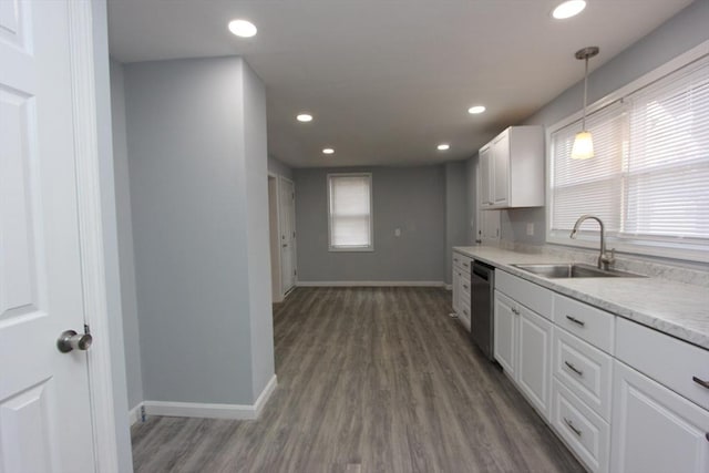 kitchen with sink, dishwasher, dark hardwood / wood-style floors, white cabinetry, and hanging light fixtures