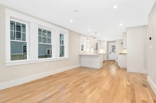 unfurnished living room with light wood-type flooring, baseboards, visible vents, and recessed lighting