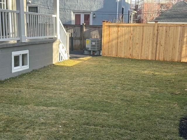 view of yard with fence and central AC