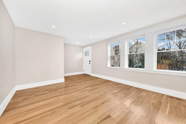 empty room featuring light wood-style flooring, baseboards, and recessed lighting