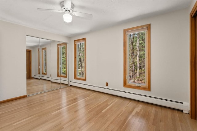 spare room with baseboards, a baseboard radiator, ceiling fan, and wood finished floors