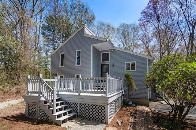 back of property with a deck and stairs