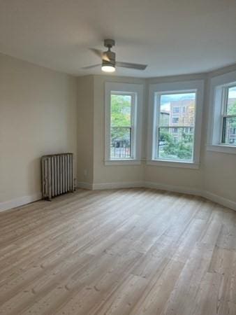 1258 Commonwealth Ave Unit 8, Boston, MA 02134 - unfurnished room featuring radiator, wood finished floors, baseboards, and ceiling fan