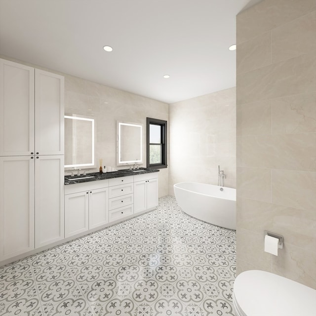 bathroom featuring toilet, tile patterned flooring, vanity, a washtub, and tile walls