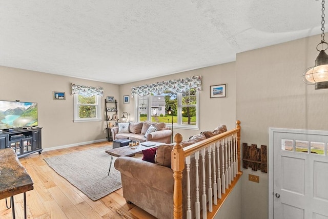 8 Stackpole Cir, Bourne, MA 02532 - living room featuring a textured ceiling, light wood-type flooring, and baseboards
