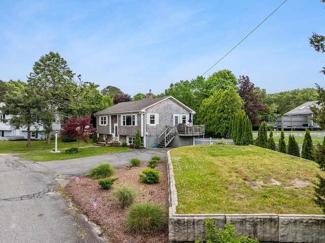 8 Stackpole Cir, Bourne, MA 02532 - view of front of property with driveway, a chimney, a front lawn, and a wooden deck