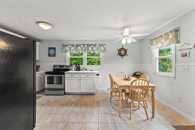 8 Stackpole Cir, Bourne, MA 02532 - kitchen with stainless steel appliances, healthy amount of natural light, wainscoting, a textured ceiling, and light countertops
