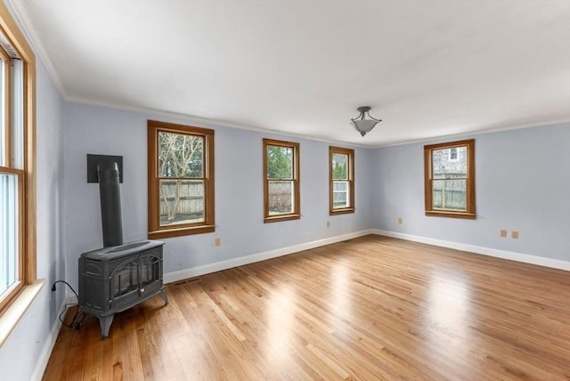living room with plenty of natural light, ornamental molding, baseboards, and light wood-type flooring