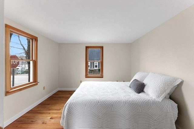 bedroom with baseboards and wood finished floors