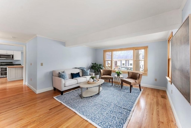 living room with baseboards, ornamental molding, visible vents, and light wood finished floors