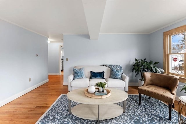 living room with baseboards, wood finished floors, beam ceiling, and ornamental molding