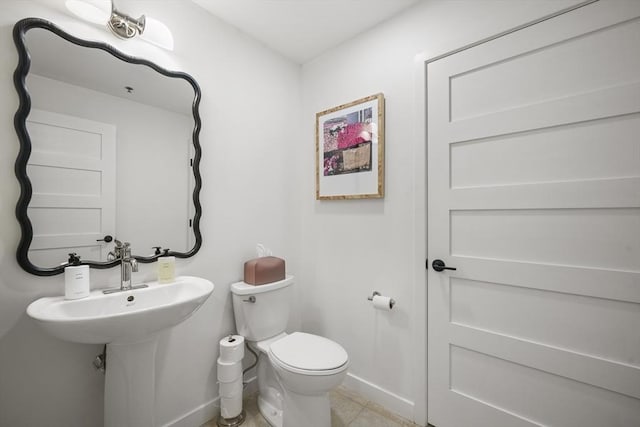 bathroom with sink, toilet, and tile patterned flooring