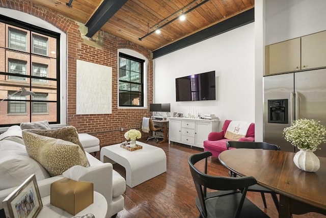 living room with brick wall, built in desk, dark hardwood / wood-style flooring, track lighting, and wooden ceiling