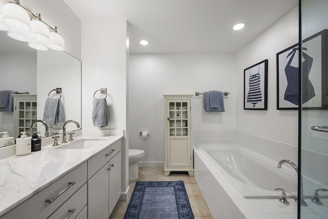 bathroom with vanity, toilet, and tiled tub