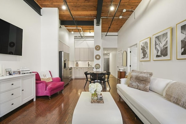 living room with dark wood-type flooring, wooden ceiling, and a high ceiling