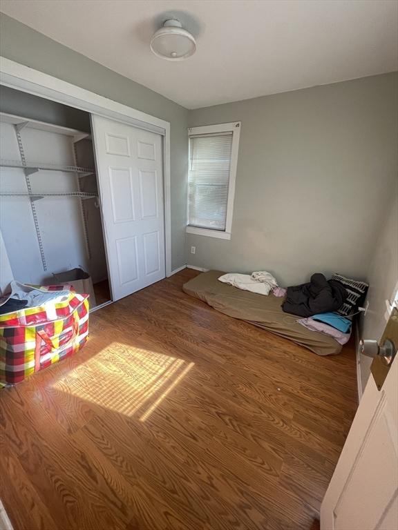 unfurnished bedroom with hardwood / wood-style flooring and a closet