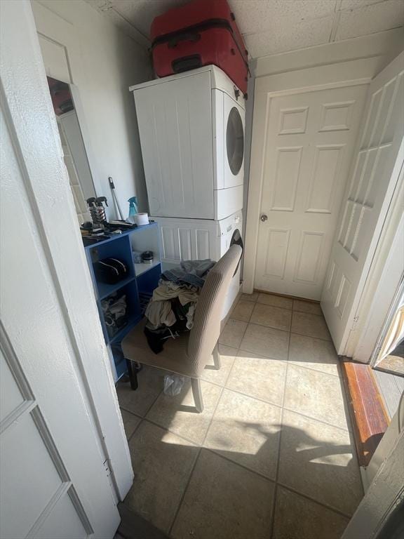 washroom featuring light tile patterned flooring and stacked washer / drying machine