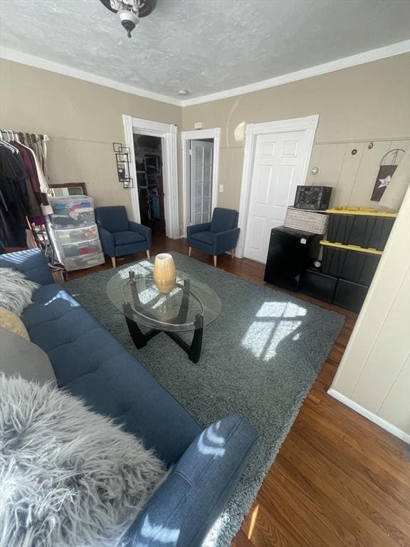 living room featuring ornamental molding, a textured ceiling, and dark wood-type flooring