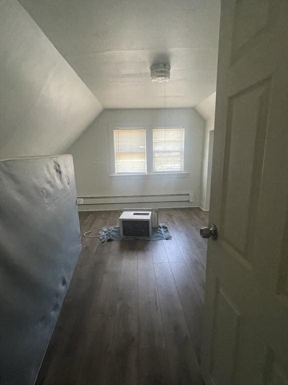 additional living space featuring dark hardwood / wood-style flooring and vaulted ceiling