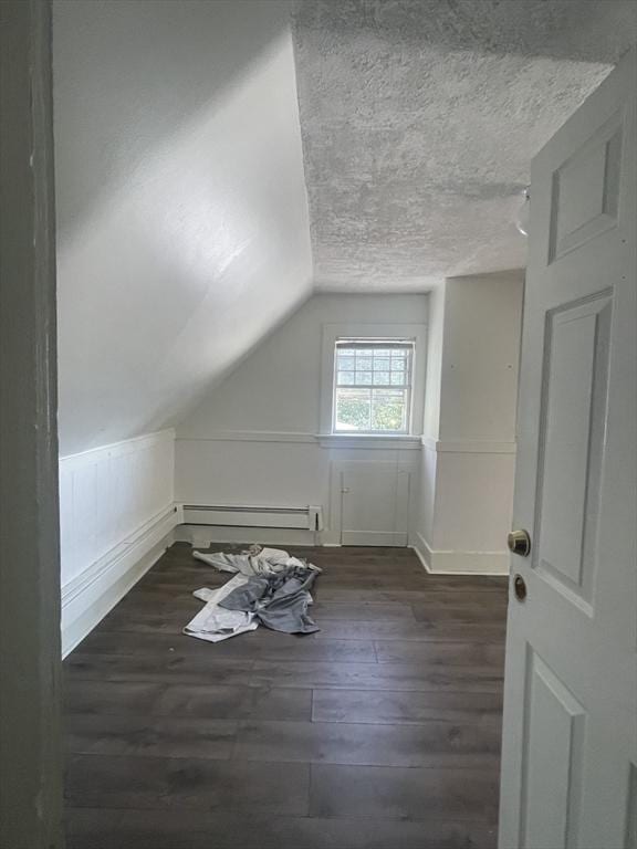 bonus room with a textured ceiling, a baseboard radiator, vaulted ceiling, and dark hardwood / wood-style floors