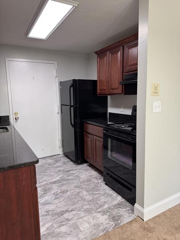 kitchen with black appliances, extractor fan, and a textured ceiling