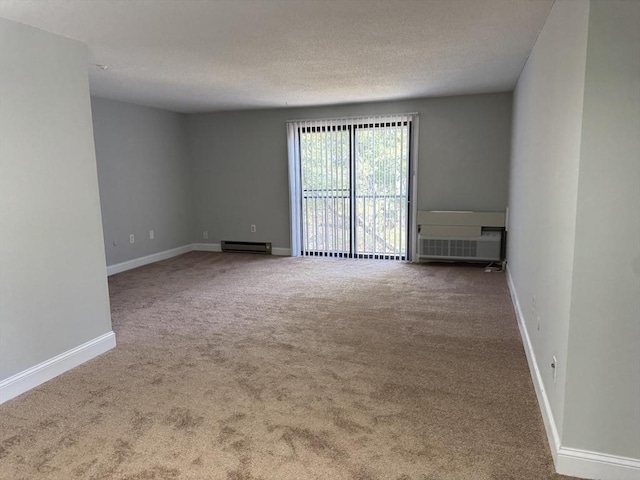 carpeted spare room with a baseboard radiator, baseboards, and a textured ceiling