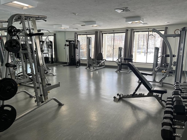 gym with visible vents and a textured ceiling