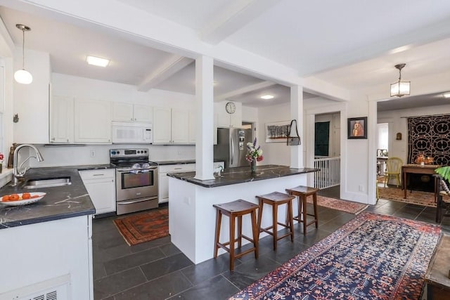 kitchen with decorative light fixtures, white cabinetry, sink, and appliances with stainless steel finishes