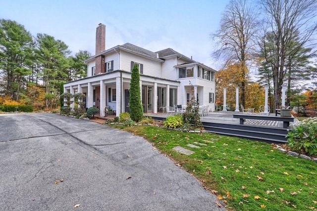 exterior space featuring a sunroom and a lawn