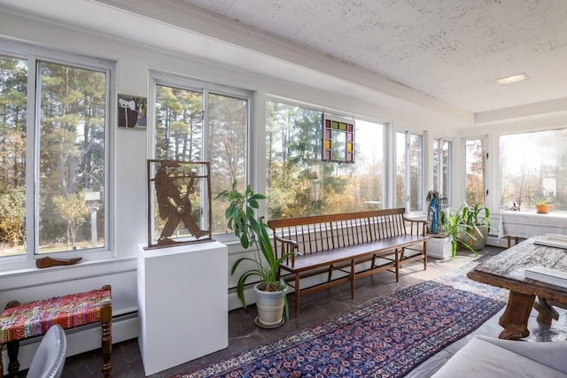 sunroom with plenty of natural light and a baseboard heating unit