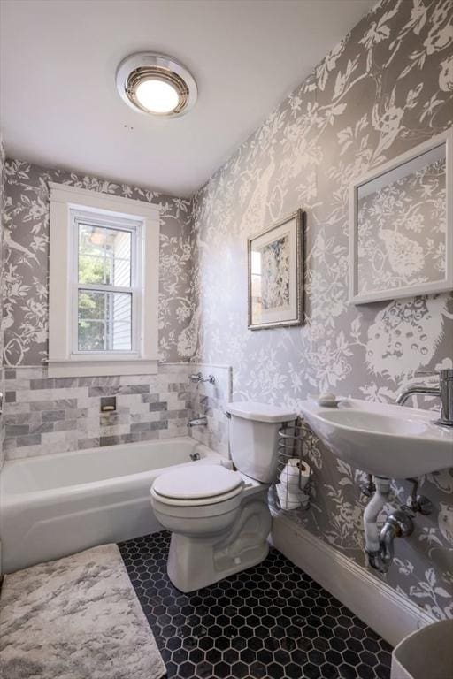 bathroom featuring tile patterned flooring, toilet, and a bathing tub