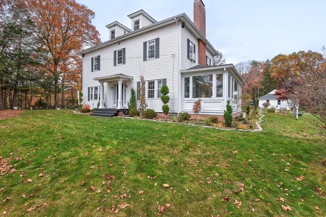 view of front of house with a sunroom and a front lawn