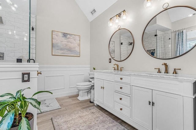 14 Glen Rd, Hopkinton, MA 01748 - full bath with a tile shower, lofted ceiling, double vanity, wood finished floors, and a wainscoted wall