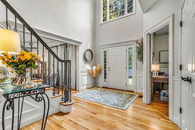 14 Glen Rd, Hopkinton, MA 01748 - entrance foyer with a high ceiling, stairs, wood finished floors, a decorative wall, and a wainscoted wall