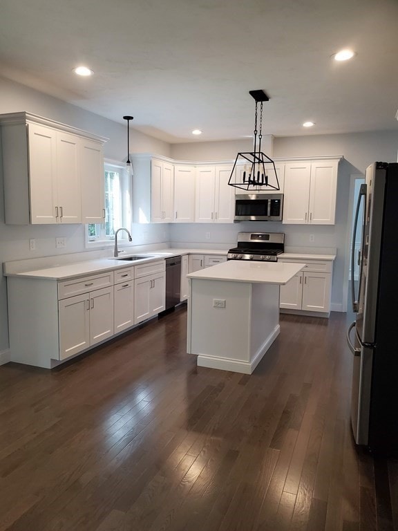 kitchen featuring pendant lighting, a center island, dark hardwood / wood-style floors, sink, and appliances with stainless steel finishes