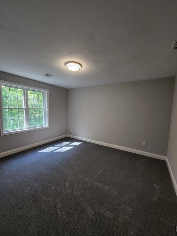 empty room featuring dark colored carpet