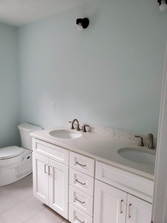 bathroom with vanity, tile patterned flooring, and toilet